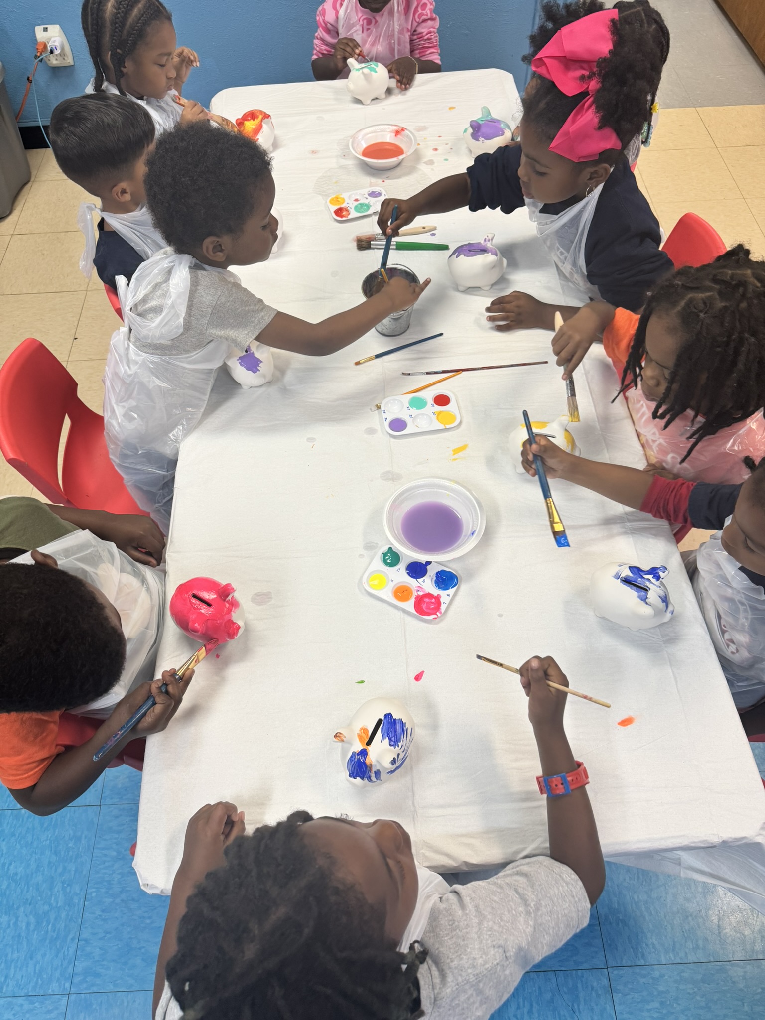 Tarrant County's CU, Saintsville Students Painting Piggy Banks