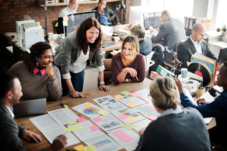 Group of people gathered around a table at work, smiling