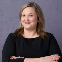 smiling person with long curly blond hair and red lipstick